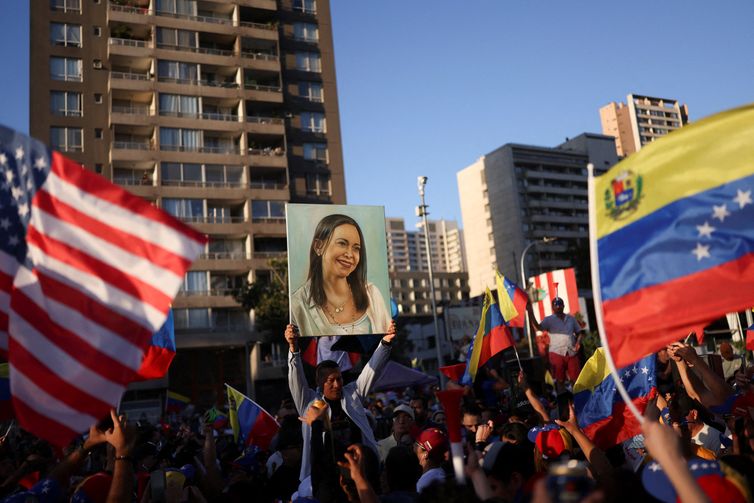 Manifestante segura cartaz com a imagem da líder da oposição venezuelana María Corina Machado durante manifestação em Santiago
03/01/2026 REUTERS/Pablo Sanhueza