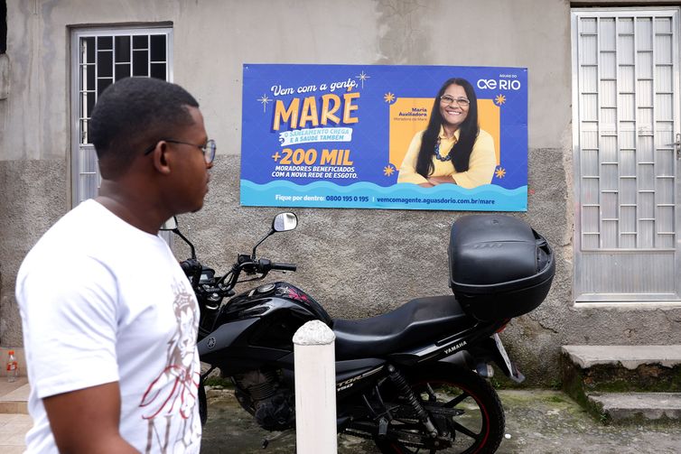 Rio de Janeiro (RJ), 01/04/2026 - Cartaz da Águas do Rio avisa das obras de infraestrutura na comunidade de Nova Holanda. Saneamento básico em localidades do Complexo da Maré. Foto: Tânia Rêgo/Agência Brasil